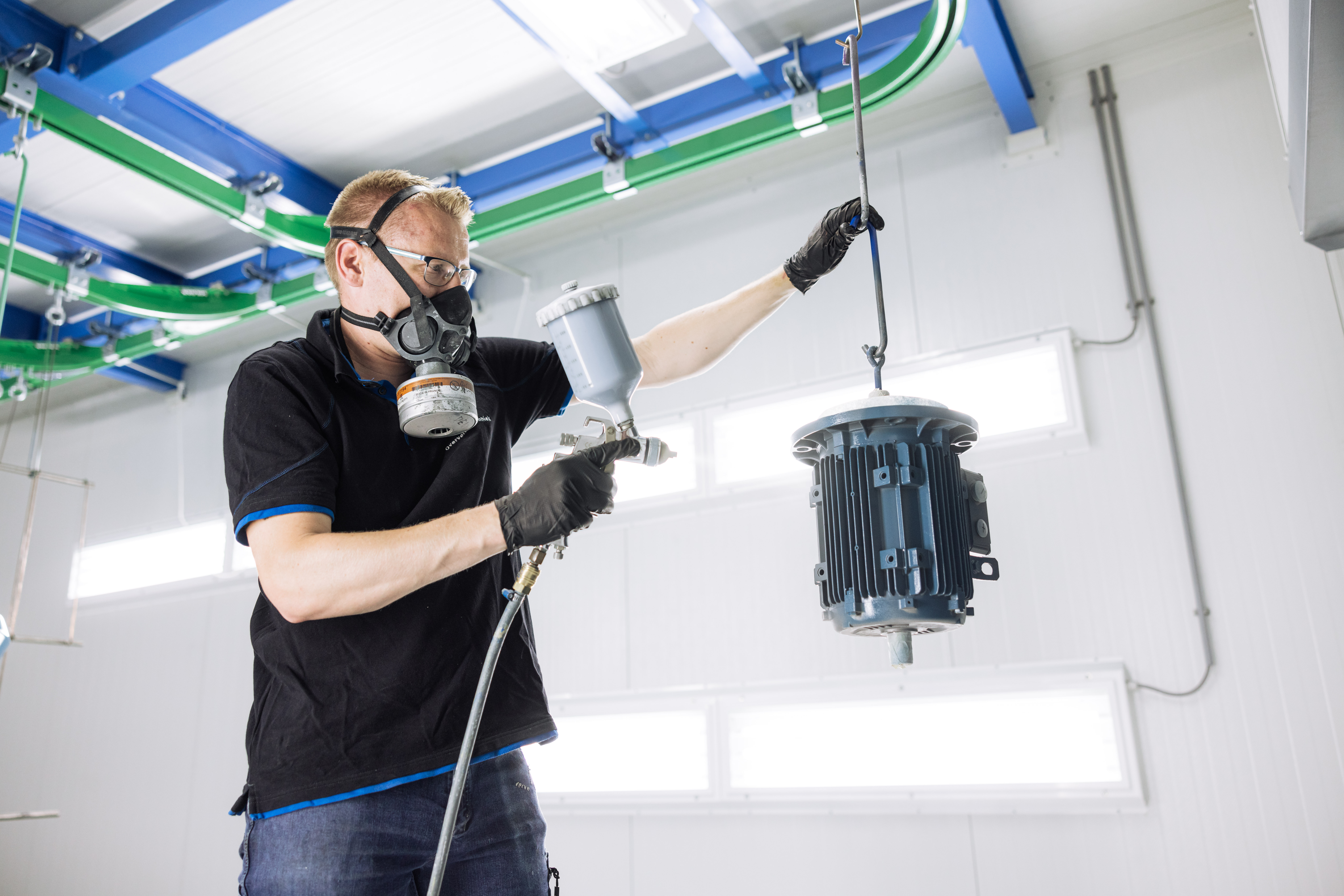 technisch medewerker Overveld techniek die een elektromotor aan het spuiten is